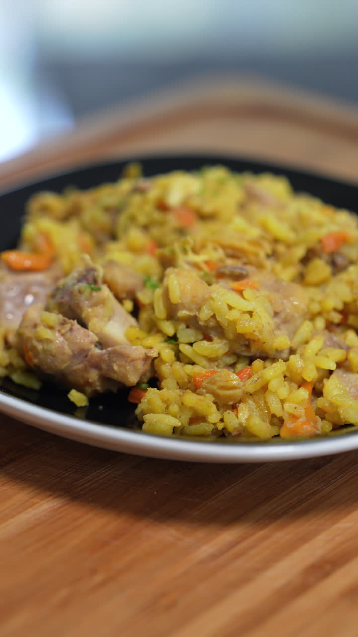 Delight in a vertical video close-up of authentic Colombian arroz con pollo. Vibrant colors and savory textures under soft natural lighting make this dish irresistible. Ideal for mobile, social media