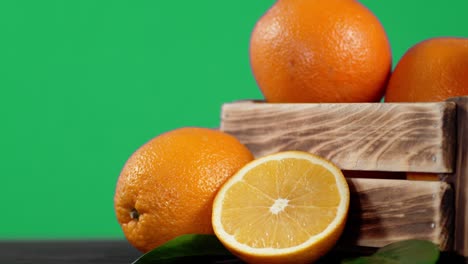 oranges in a wooden box slowly rotate.