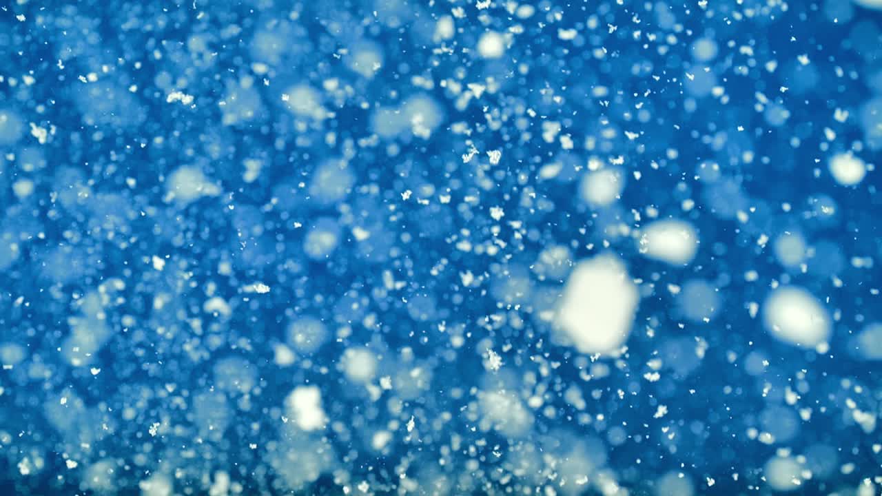 Thick snowy blizzard layers drift down fast on blue field for dynamic visuals