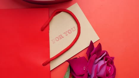 gift, card, and rose on red background