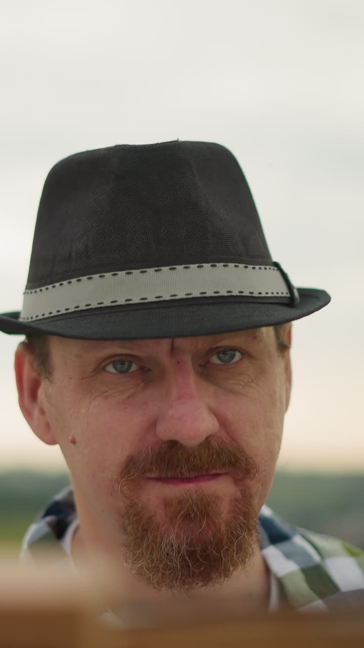 검은 모자를 입은 예술가, 눈에 보이지 않는 작업에 집중하고, 모기가 눈에 띄게 머리 주위에 날아다니고, 앞에 부분적으로 보이는 보드는 그가 중요한 작업을 하고 있다는 것을 암시합니다.