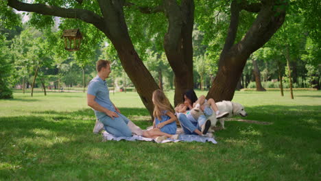 cheerful parents tickling kids on picnic. family amusement on summer weekend.