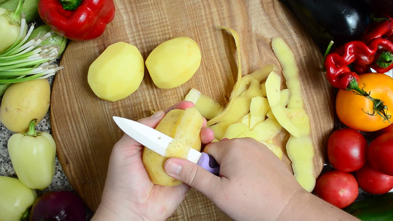 Il cuoco sbuccia le patate. Preparazione delle verdure.