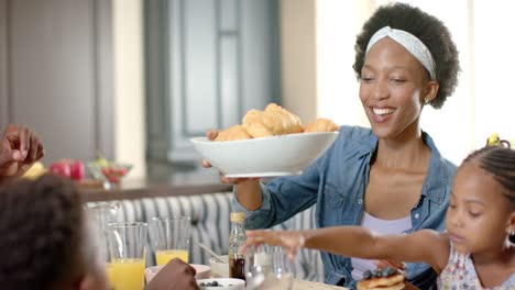 una feliz familia afroamericana desayunando, en cámara lenta