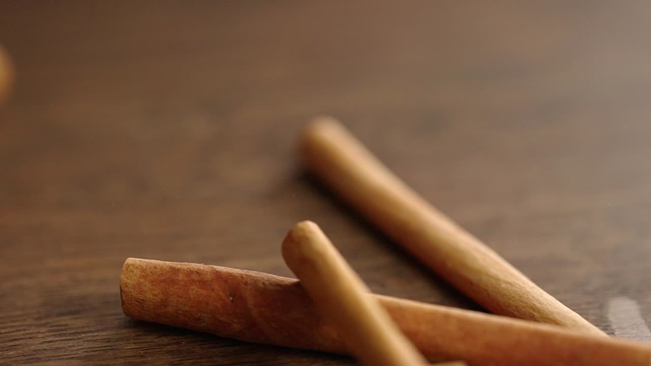 Kanelstenger faller ned på en treflate, super sakte film