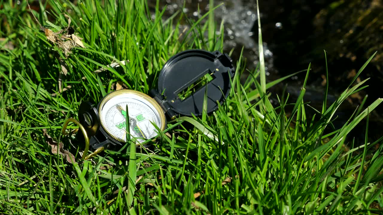 Compass on the grass near litle stream