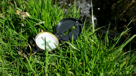 compass on the grass near litle stream