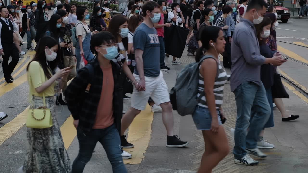 Hong Kong - June 3, 2020: Slow motion of crowd people wearing medical face masks in Hong Kong. Coronavirus concept. Covid-19.