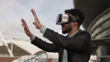 smiling middle eastern man using virtual reality headset outdoor