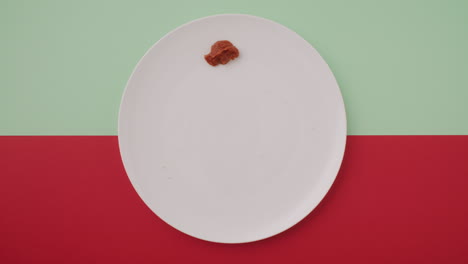 Empty Plate with Sauce on a Red and Green Background