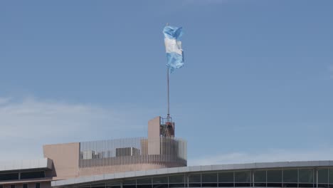 Scenic-Footage-of-the-Argentine-Flag-Fluttering-Proudly-at-Punta-del-Centinela-on-a-Sunlit-Day,-Capturing-the-Patriotic-Spirit-Amidst-the-Picturesque-Landscape