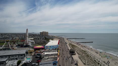 Toma-Aérea-Sobre-La-Ciudad-Del-Océano,-El-Paseo-Marítimo-De-Nueva-Jersey-En-Un-Día-Cálido-Y-Soleado