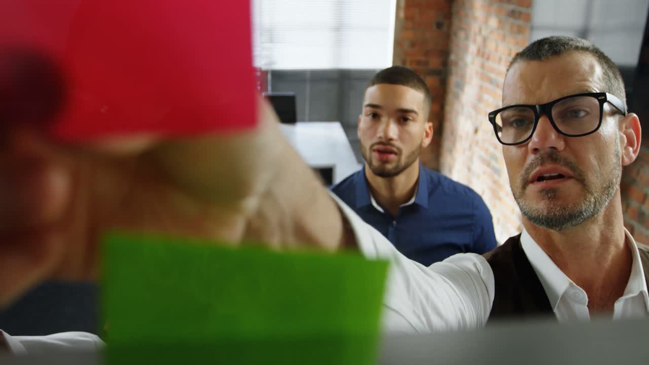 Dirigenti che discutono su post-it in ufficio 4k