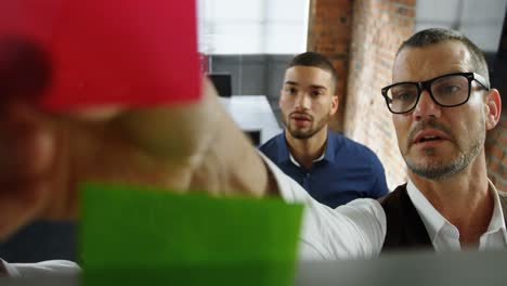 Executives-discussing-on-sticky-note-in-office-4k