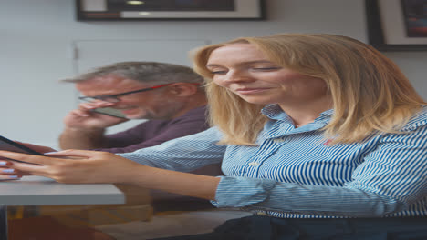 Vertical-Video-Of-Customers-In-Coffee-Shop-Window-Browsing-And-Making-Calls-On-Mobile-Phone