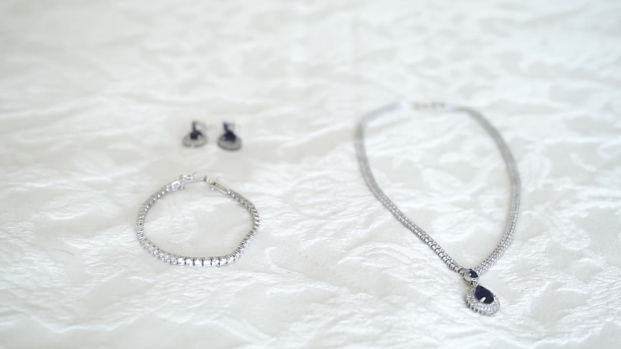 흰색 침대 시트에 있는 보석의 클로즈업 샷