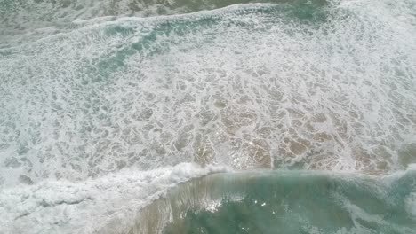 Siguiendo-Las-Olas-En-Una-Playa-Con-Un-Dron,-Vista-De-ángulo-Alto