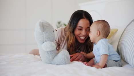 Happy,-mom-and-baby-with-teddy-bear-in-bed