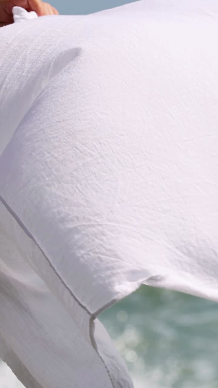 белая ткань вращается на фоне океана.