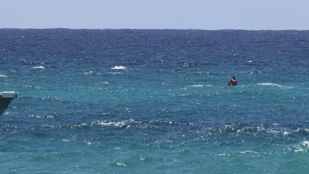 una lancha rápida tira de un esquiador de agua en el océano azul vibrante