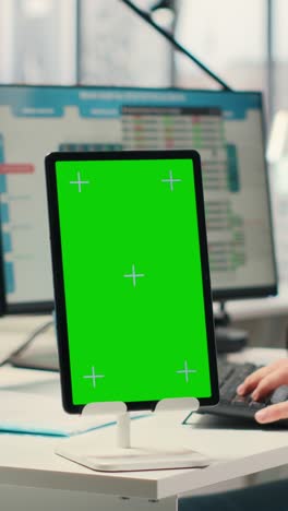 vertical video business consultant examining forecasts with chroma key on tablet