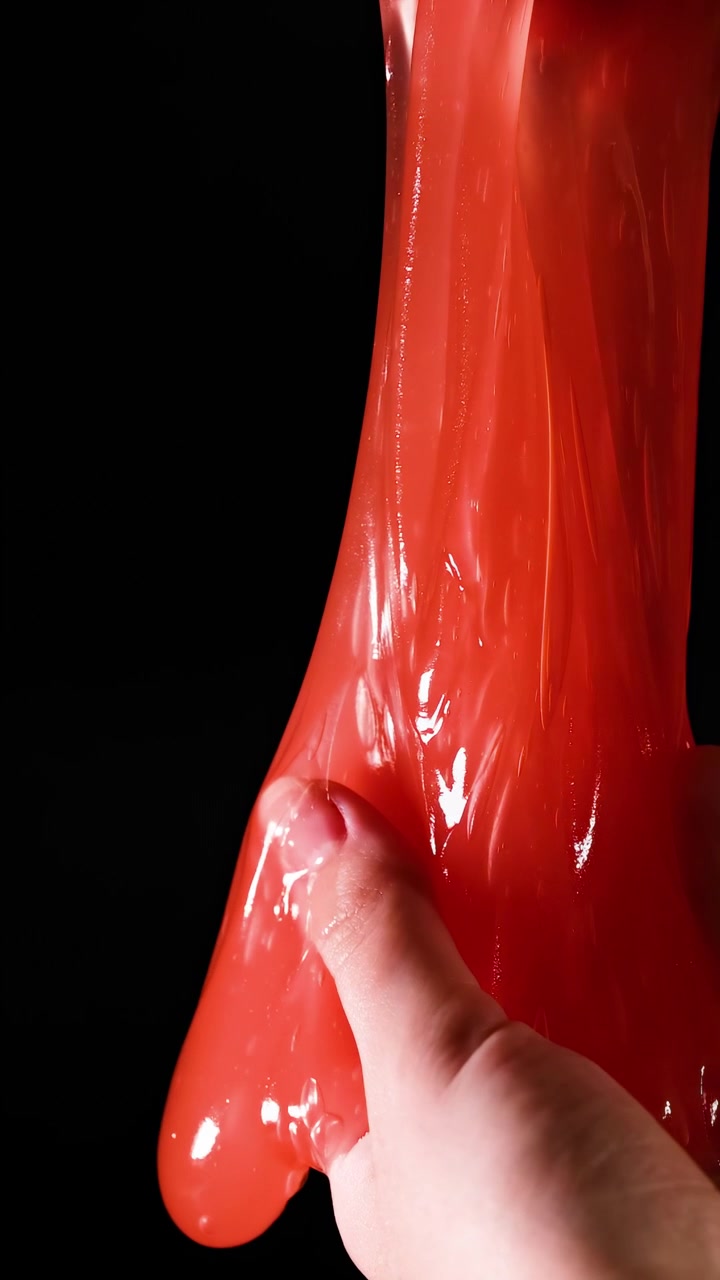 Mani che allungano e stringono slime rosso