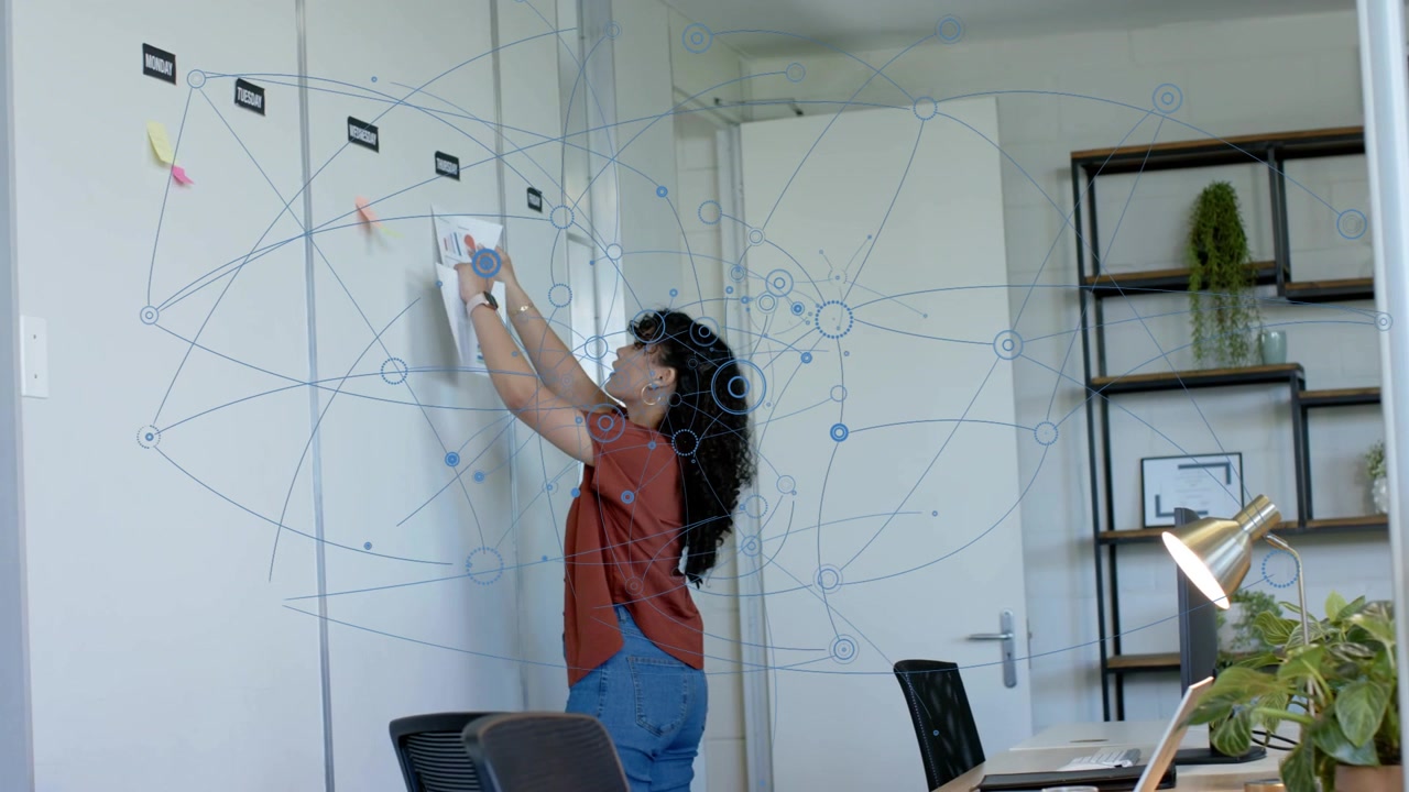 Woman walking to panels placing pages, aligning sticky notes for office plan as blue network grows