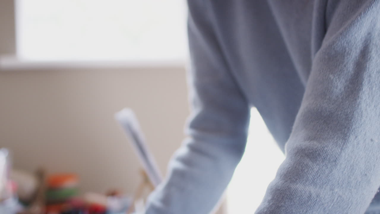 primer plano de una artista adolescente enmarcando una imagen en un estudio