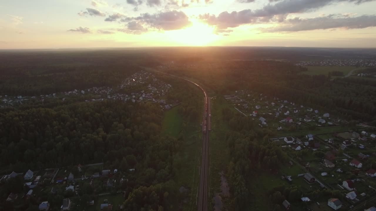 volando sobre el campo y el tren de carga al atardecer en rusia