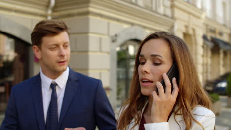 successful business couple having phone call outdoors