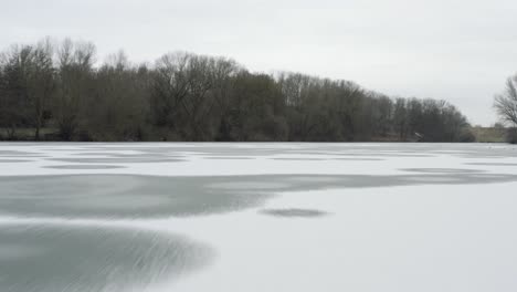 drone aerial footage of a 4k drone flying very close over a frozen lake in germany