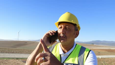 Male-engineer-talking-on-mobile-phone-in-the-wind-farm-4k