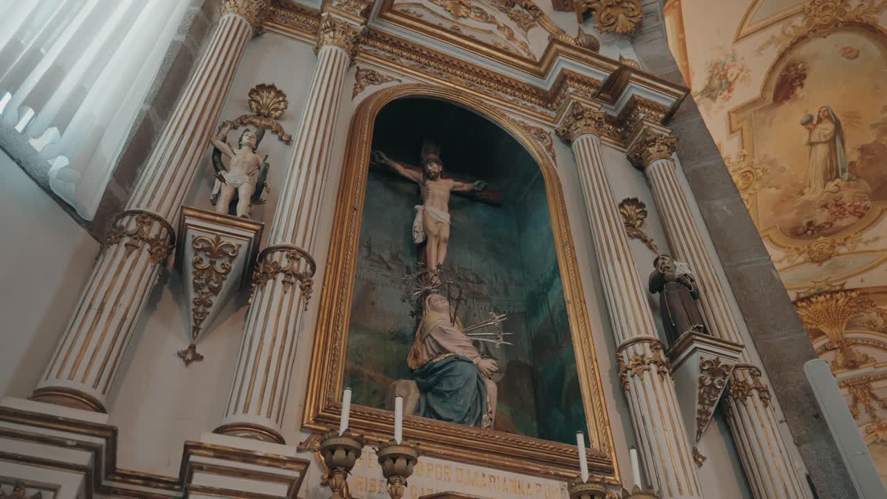 Crucifix altar and richly painted ceiling inside ornate historic church