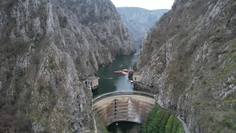 vista de avión no tripulado de la presa y el edificio en el río treska que pasa por el cañón de matka, atletas en canoa en el río