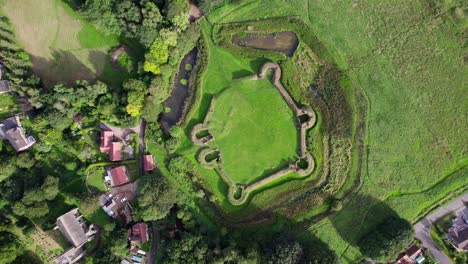 Aerial-video-footage-of-the-remains-of-Bolingbroke-Castle-a-13th-century-hexagonal-castle,-birthplace-of-the-future-King-Henry-IV,-with-adjacent-earthwork