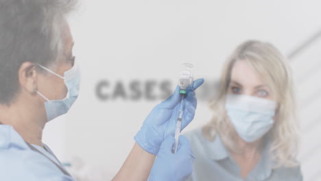 animation of covid 19 text over woman receiving vaccination wearing face mask