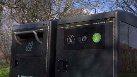 a garbage and recycling bin in garden society of gothenburg, sweden, pan left