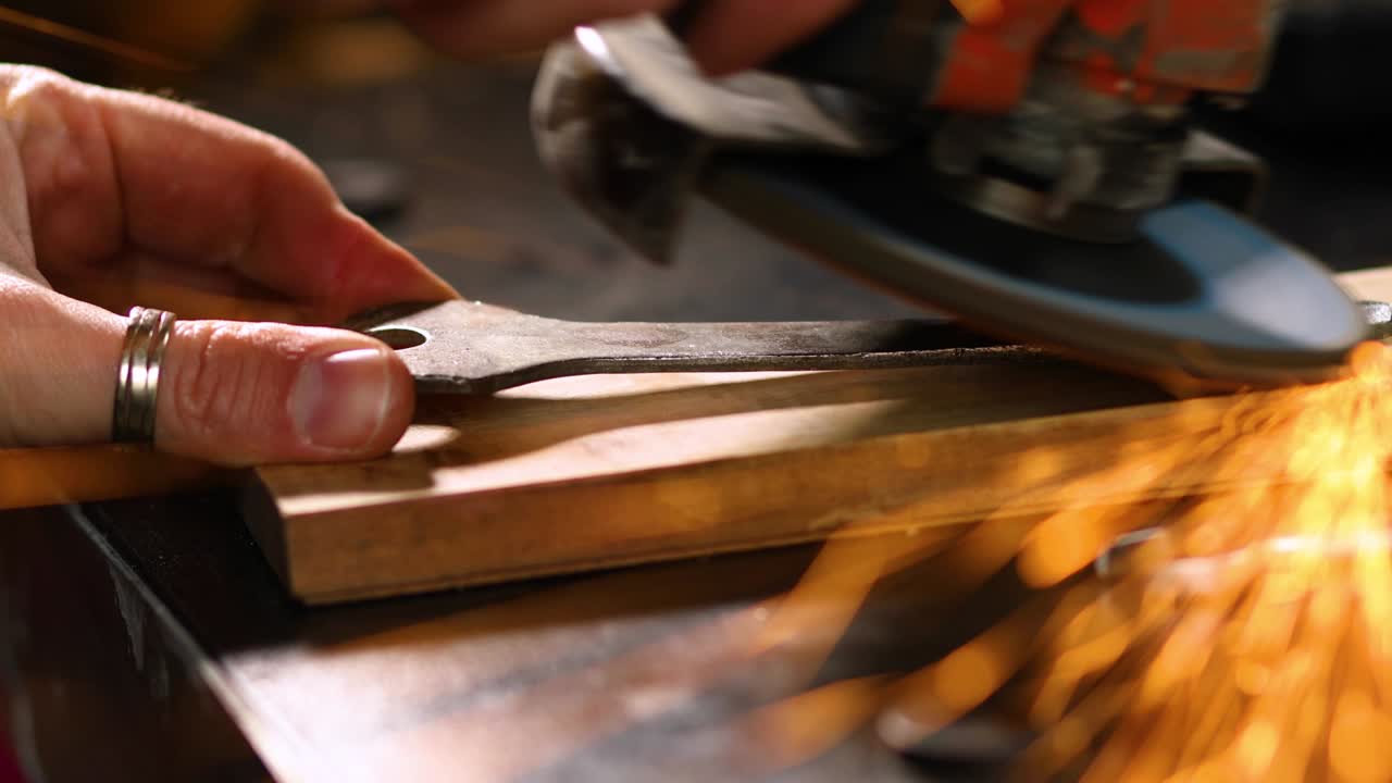 cerrajero de cerca trabaja con la máquina de moler, volar chispas brillantes