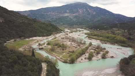 volando y aumentando la altitud sobre el río evinos en grecia en una tarde nublada de primavera