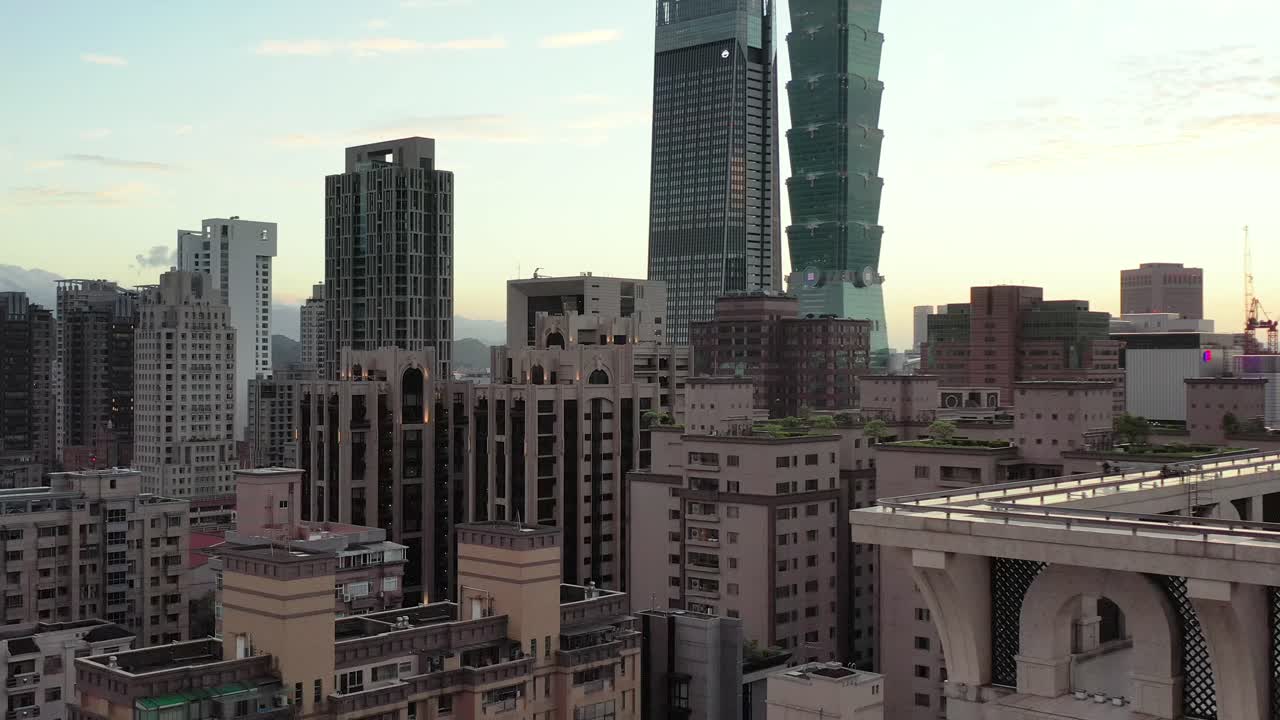 pedestal aéreo cinematográfico que captura el paisaje urbano y el edificio más alto taipei 101 en el distrito céntrico de xinyi, taiwán, en las horas doradas del atardecer