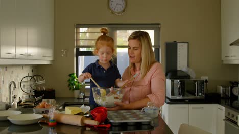 madre y hijo felices mezclando harina en la cocina 4k