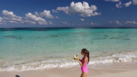 woman drinking coconut water on a tropical beach