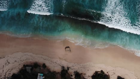 印尼巴厘島烏魯瓦圖 (uluwatu) 的<unk>加蘭海灘 (nunggalan beach) 的海浪逐一滾動的空中景色 | 巴厘島,南庫塔