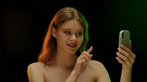 Young Woman Taking Selfie in Colorful Studio Light