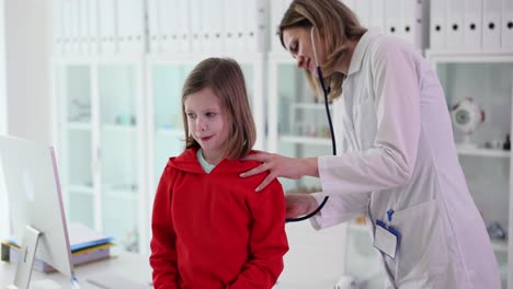 a doctor examines a young child with a stethoscope in a clinic setting