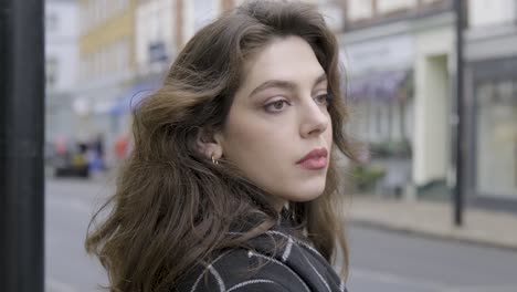 close up of brunette businesswoman waiting and trying to cross busy traffic street crosswalk in central london