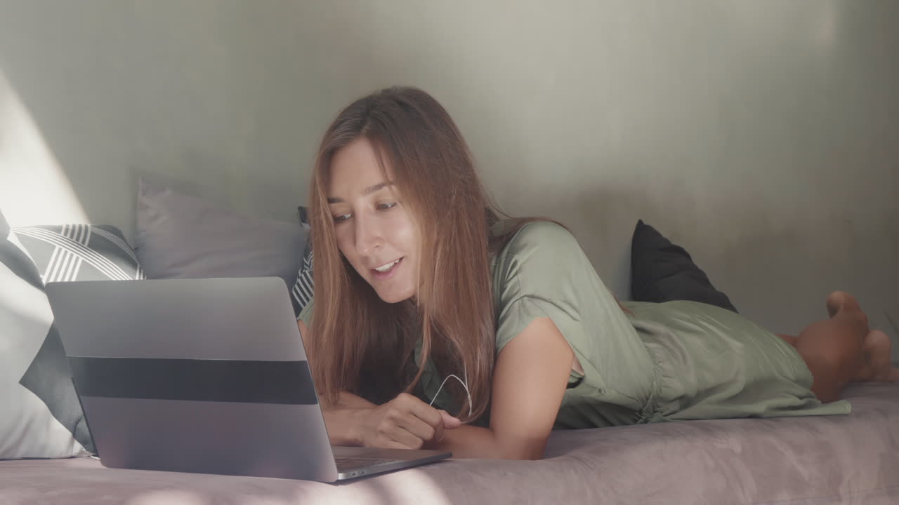 Woman Video Calling Lying on Daybed