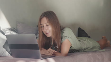 woman video calling lying on daybed