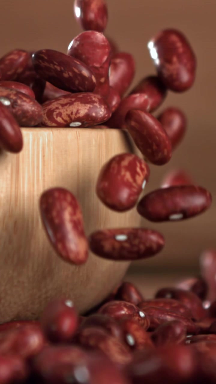 Red Kidney Beans Falling into a Wooden Bowl in Slow Motion