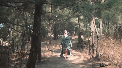 a beautiful woman in a green dress calmly walks barefoot towards the camera, connecting with nature and expressing gratitude